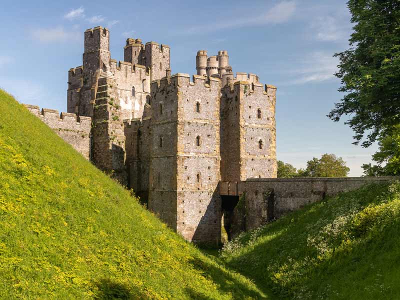 Towers and turrets of Arundel Castle and gardens in the sun.